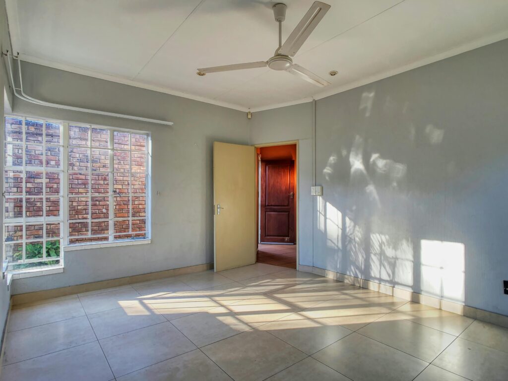 A room with a ceiling fan and tile floor